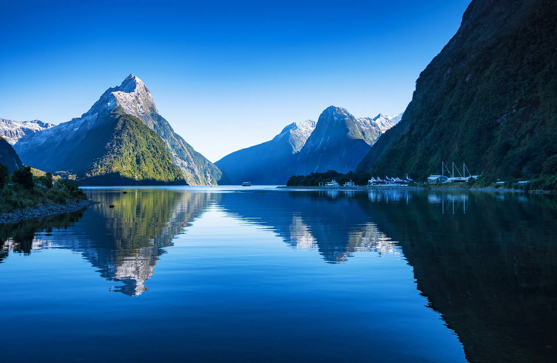Majestic view of Milford Sound in autumn, with mountains reflecting in the still water.