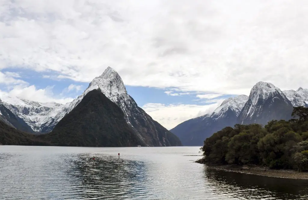 Mitre Peak in Milford Sound with snow on the mountains during a clear winter day.